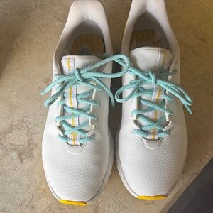 GFore ladies golf shoes white with yellow, blue laces.